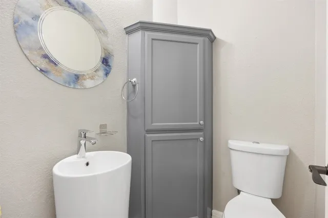 a bathroom with a toilet a sink and a mirror