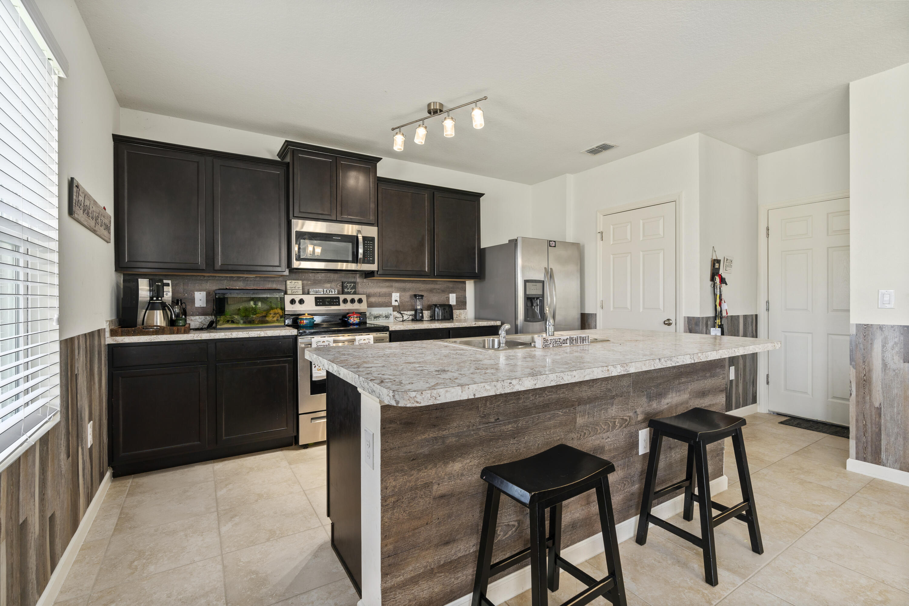 3100 Yellowstone Circle Fort Pierce, FL 34945 - Photo 12 of 28 a kitchen with stainless steel appliances granite countertop a table chairs sink and cabinets