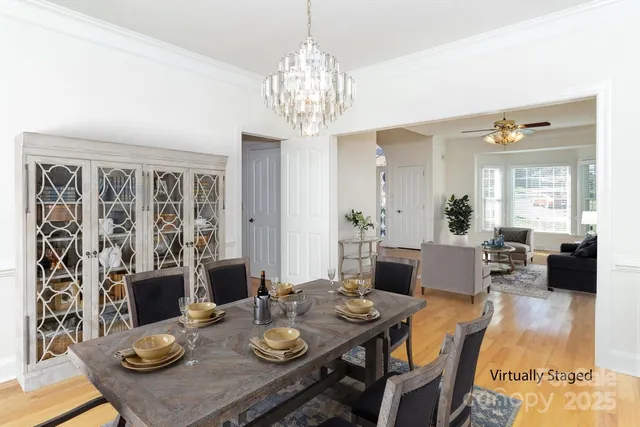 a view of a dining room with furniture a chandelier and wooden floor
