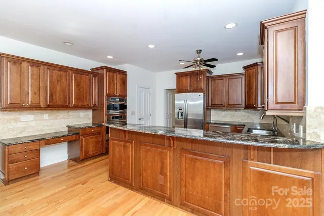 a kitchen with stainless steel appliances granite countertop a sink stove and cabinets