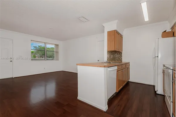 a room with a window a wooden floor and a sink