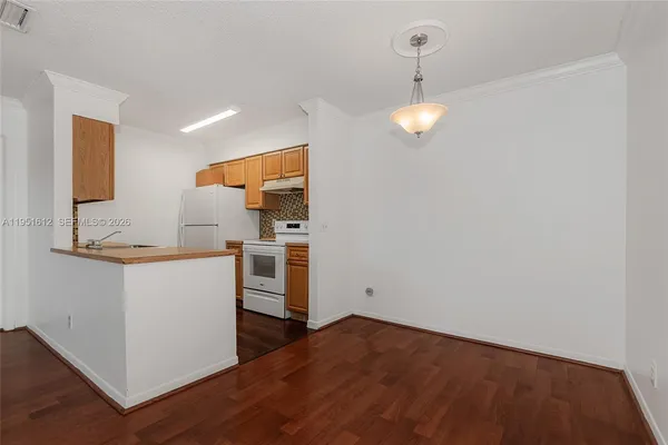 a view of a kitchen with wooden floor and electronic appliances