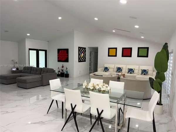 a large kitchen with stainless steel appliances kitchen island granite countertop a sink a stove and cabinets