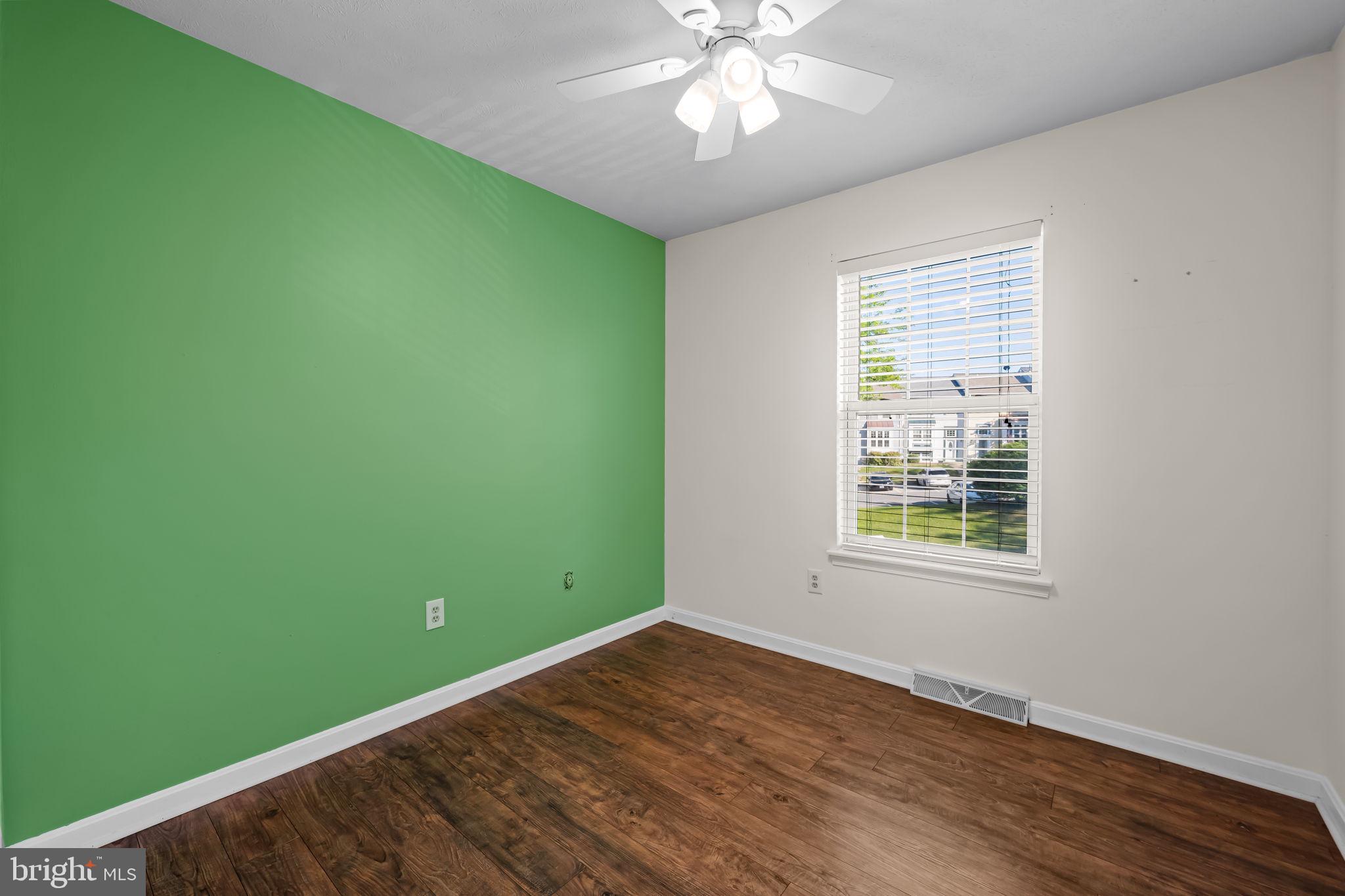 4630 Marksman Court Hampstead, MD 21074 - Photo 12 of 16 a view of an empty room with wooden floor and a window