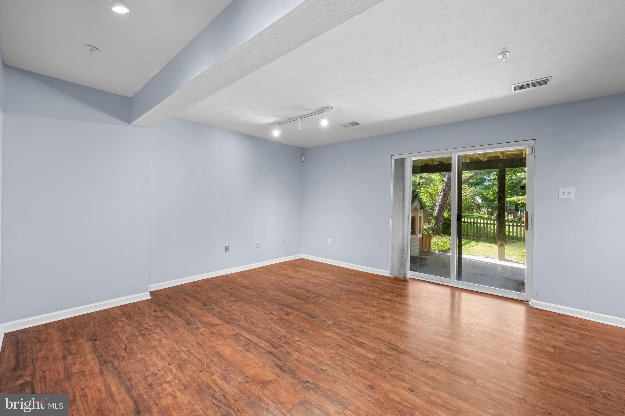 4630 Marksman Court Hampstead, MD 21074 - Photo 13 of 16 a view of an empty room with wooden floor and a window