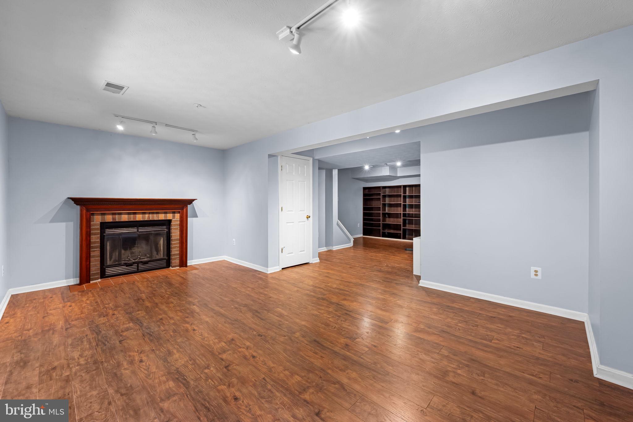 4630 Marksman Court Hampstead, MD 21074 - Photo 14 of 16 a view of an empty room with wooden floor and a fireplace