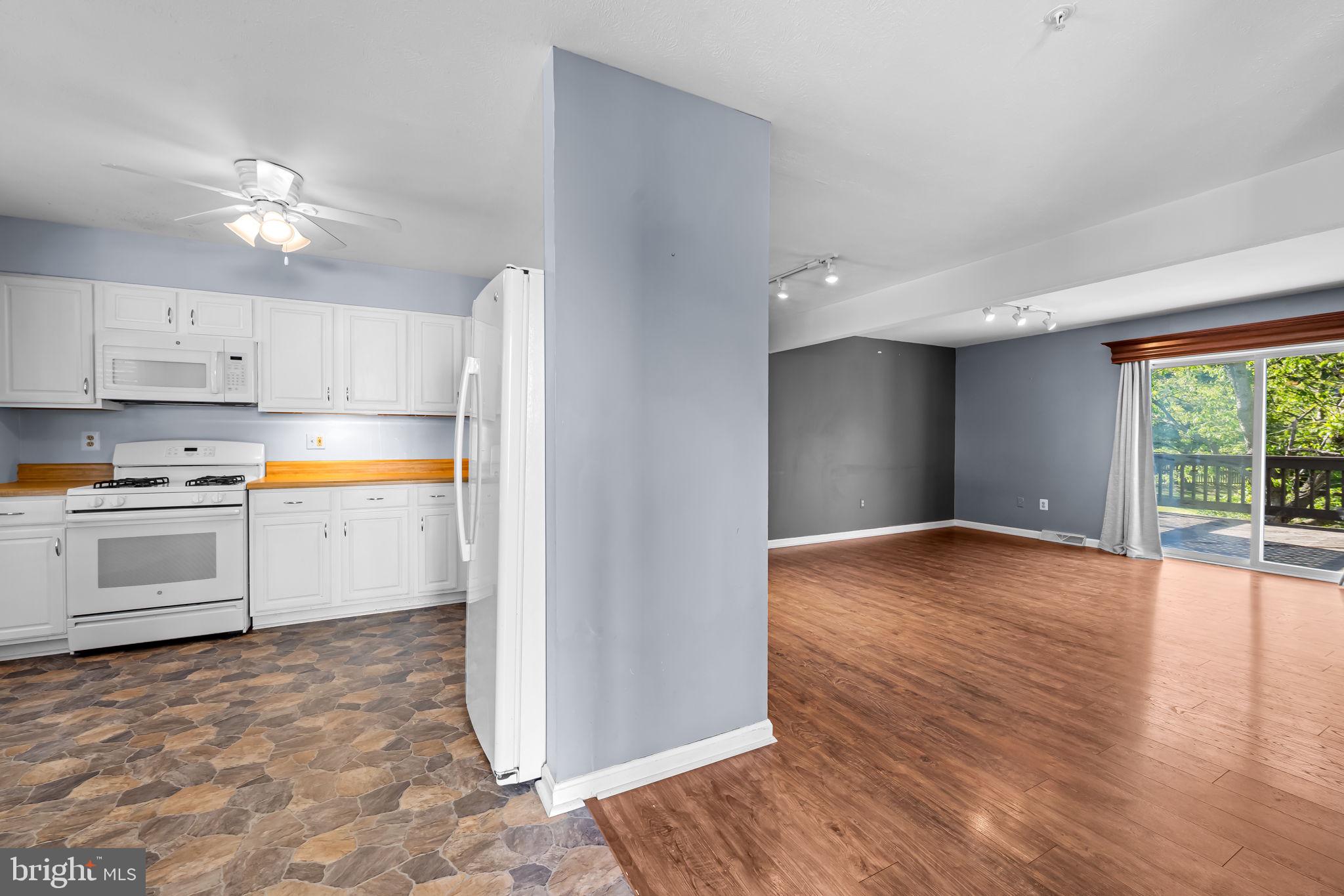 4630 Marksman Court Hampstead, MD 21074 - Photo 6 of 16 a kitchen with wooden floors and white appliances