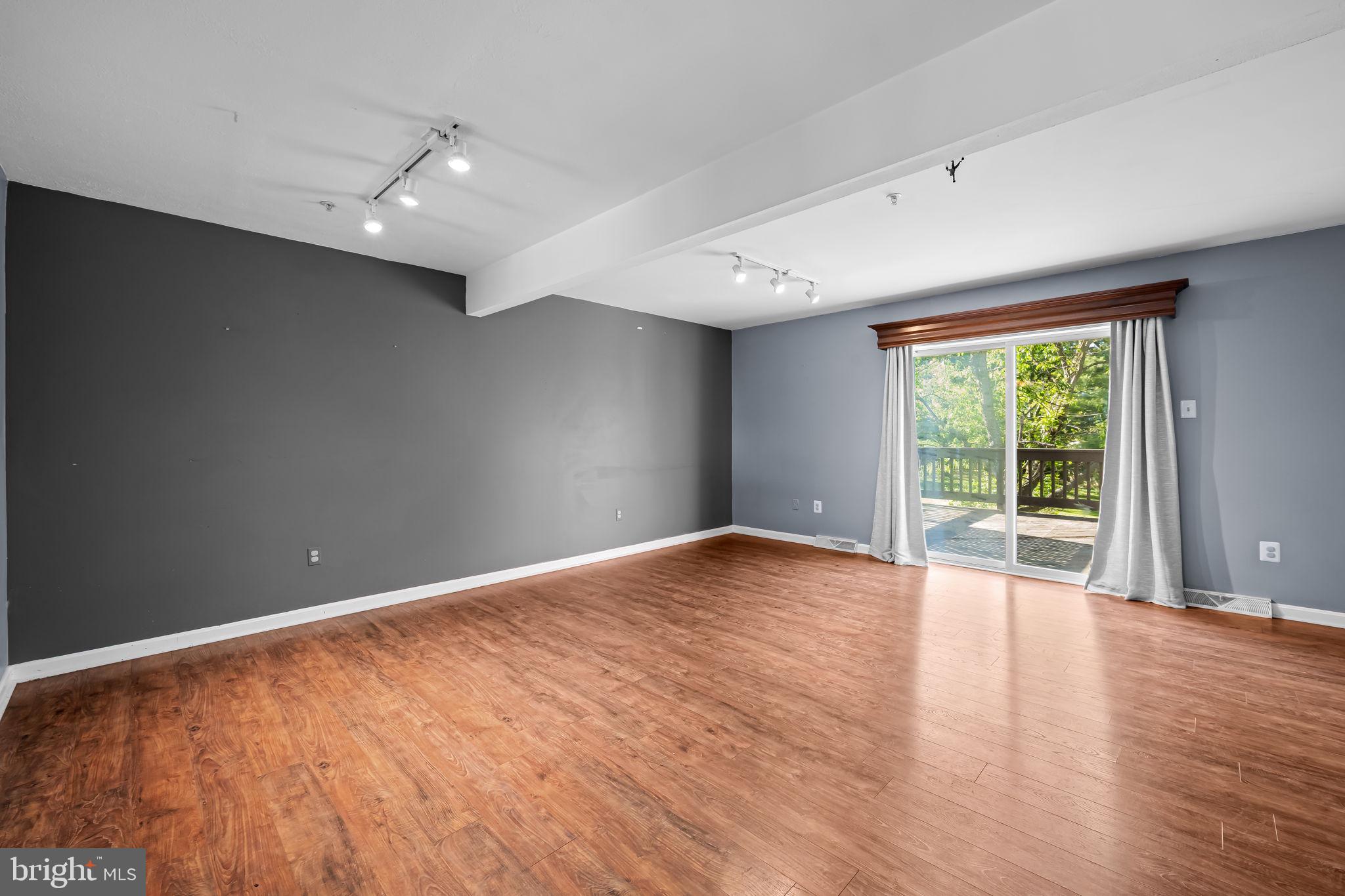 4630 Marksman Court Hampstead, MD 21074 - Photo 7 of 16 a view of an empty room with wooden floor and a window