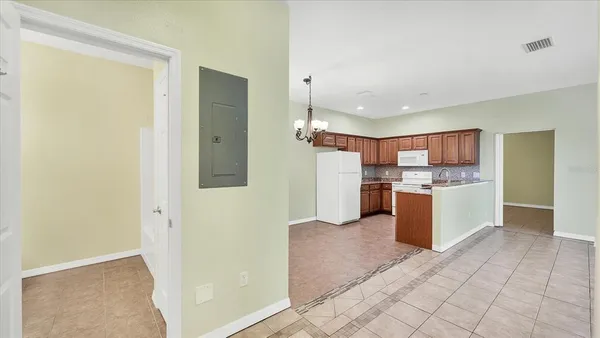 a view of kitchen with refrigerator and white cabinets