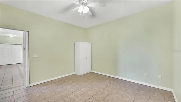 an empty room with a chandelier fan