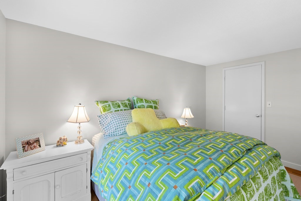 11 Oak Street, Unit 35 Wellesley, MA 02482 - Photo 18 of 22 a bedroom with a bed and a lamp on dresser