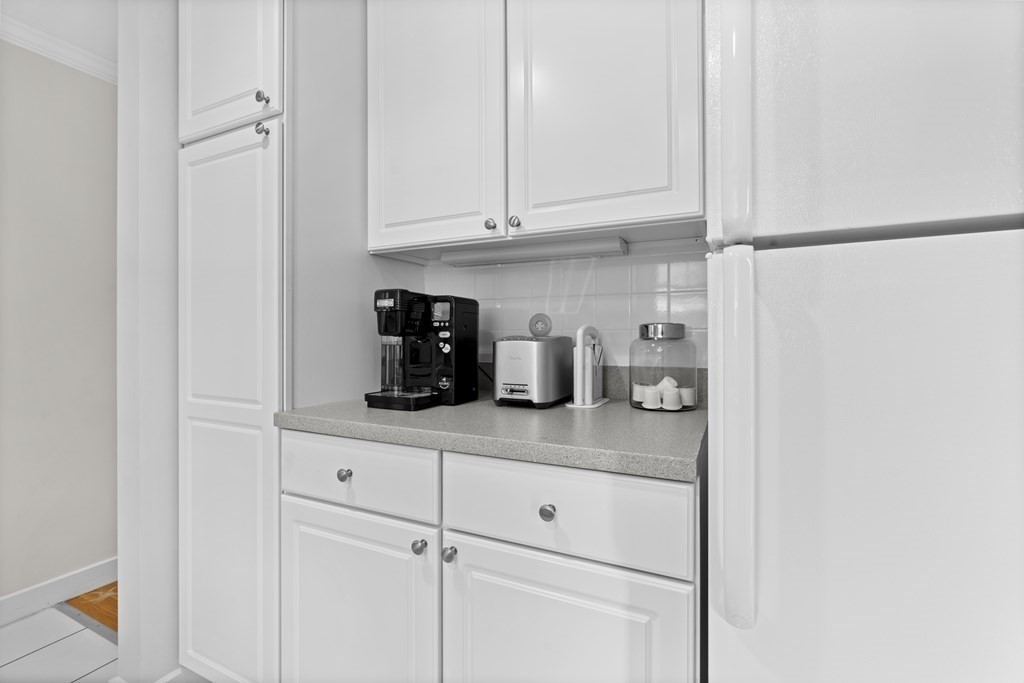 11 Oak Street, Unit 35 Wellesley, MA 02482 - Photo 5 of 22 a kitchen with a refrigerator and cabinets
