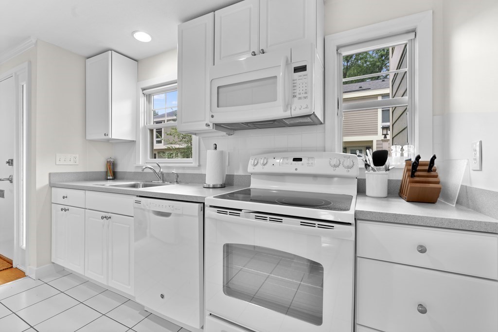11 Oak Street, Unit 35 Wellesley, MA 02482 - Photo 6 of 22 a kitchen with white cabinets and white appliances