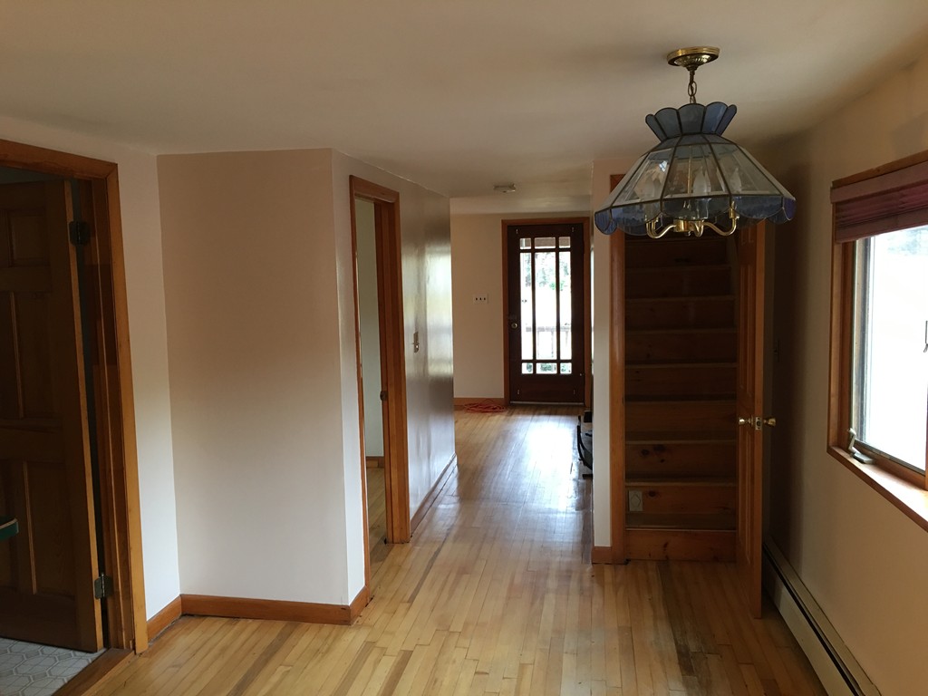 185 Shirley Road Lancaster, MA 01523 - Photo 7 of 15 a view of a hallway with wooden floor and stairs