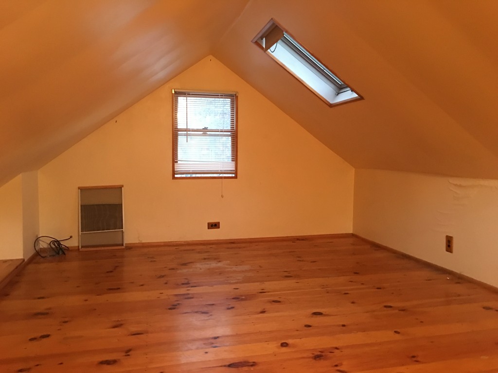 185 Shirley Road Lancaster, MA 01523 - Photo 9 of 15 a view of an empty room with wooden floor and a window
