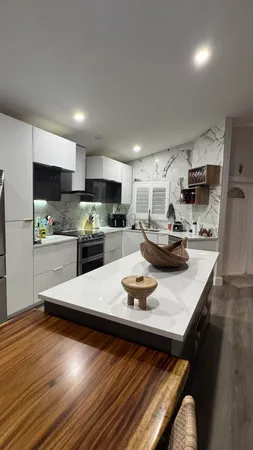 a kitchen with a sink a stove and chairs with wooden floor