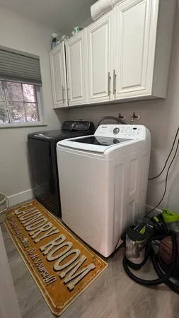 a room with water heater and white cabinets