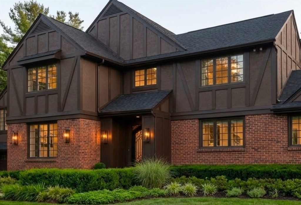 a brick house with large windows and a yard