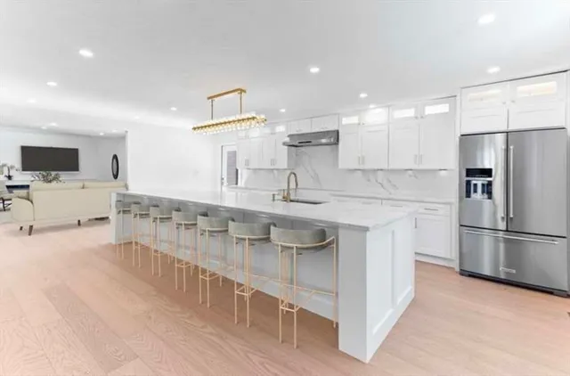a kitchen with stainless steel appliances granite countertop a sink and a refrigerator