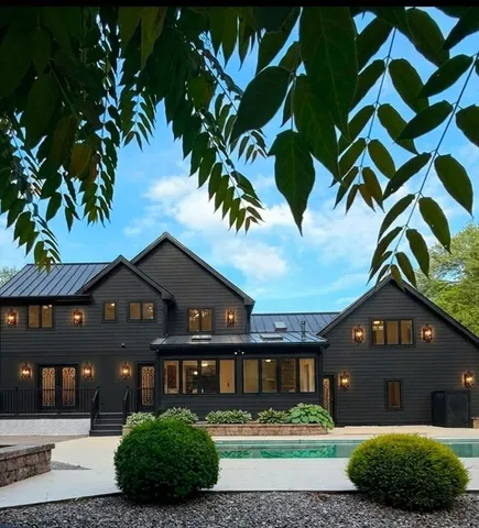a front view of a house with a yard and potted plants