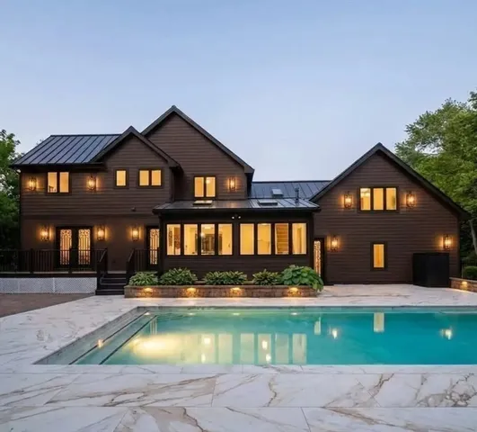 a front view of a house with yard swimming pool and outdoor seating
