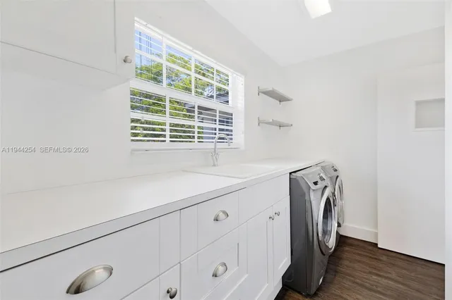 a utility room with cabinets washer and dryer