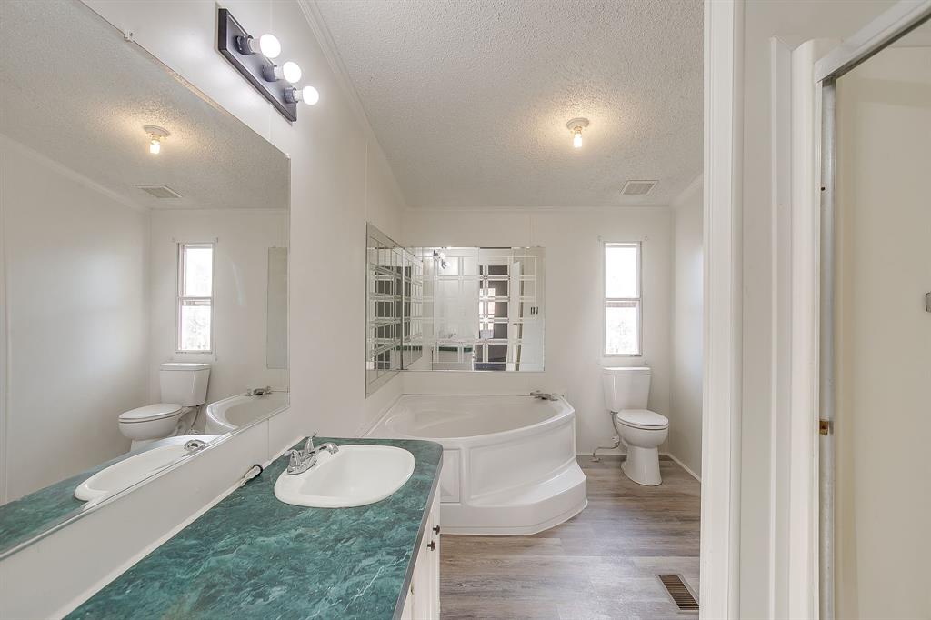 317 6th Street Joshua, TX 76058 - Photo 20 of 36 a bathroom with a granite countertop toilet sink and mirror
