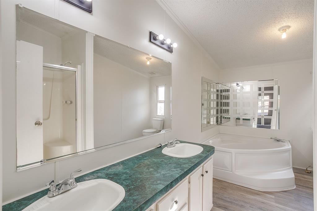 317 6th Street Joshua, TX 76058 - Photo 21 of 36 a bathroom with a granite countertop sink and a mirror