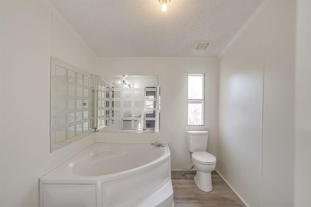 317 6th Street Joshua, TX 76058 - Photo 23 of 36 a white bath tub sitting next to a toilet