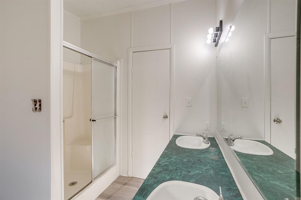 317 6th Street Joshua, TX 76058 - Photo 24 of 36 a bathroom with a granite countertop sink and a mirror