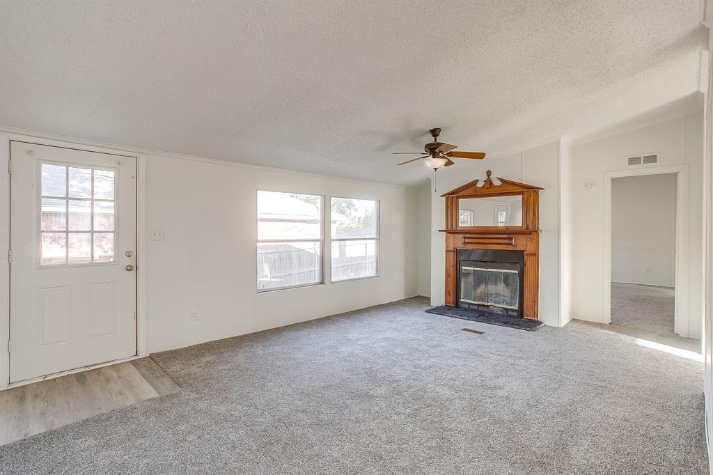 317 6th Street Joshua, TX 76058 - Photo 3 of 36 an empty room with a fireplace and a window