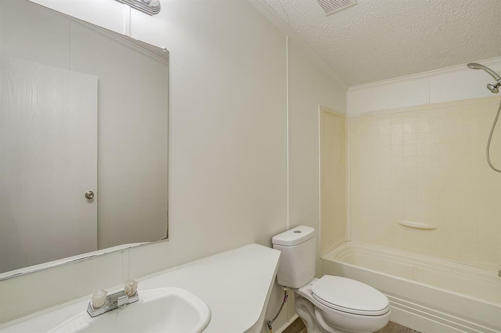 317 6th Street Joshua, TX 76058 - Photo 31 of 36 a white toilet sitting next to a bathroom sink