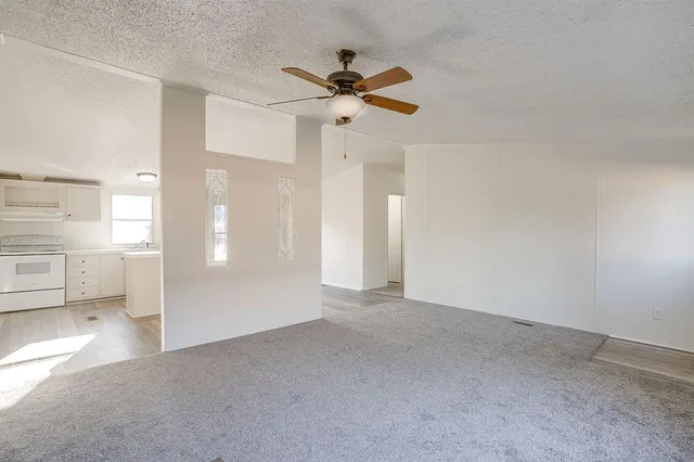 a view of a livingroom with a ceiling fan and entryway