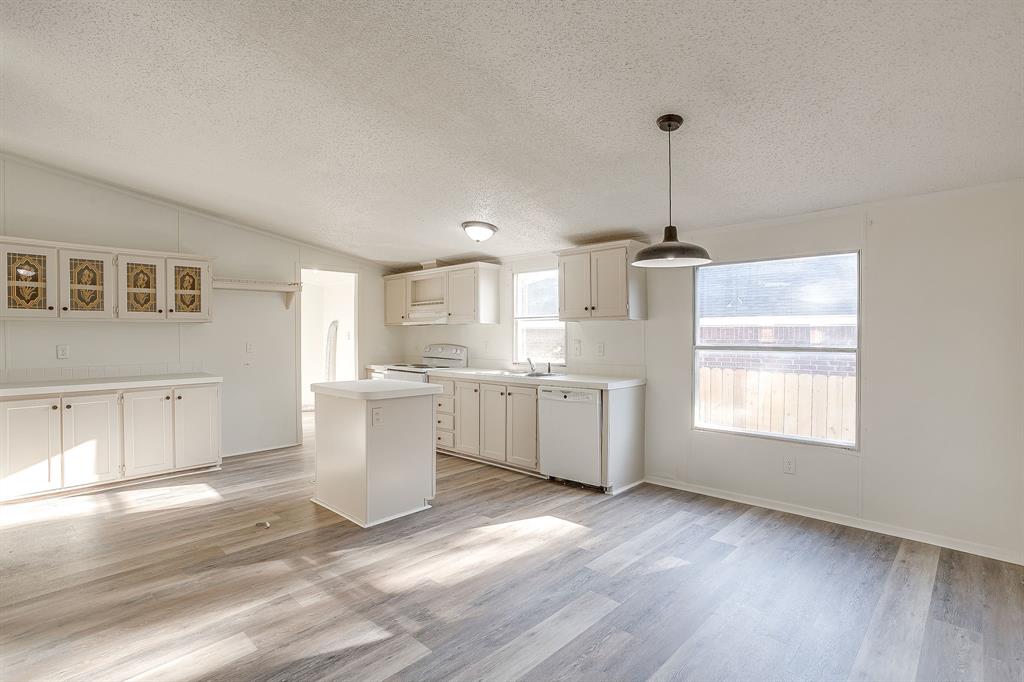 317 6th Street Joshua, TX 76058 - Photo 8 of 36 a kitchen that has a lot of cabinets and wooden floor