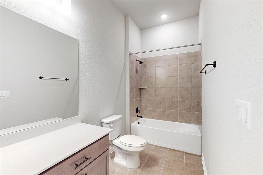 4907 Escape Rivera Drive Austin, TX 78747 - Photo 15 of 28 A well-appointed bath features a sleek vanity and a tiled shower-tub combination.