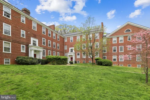 a view of a brick building next to a big yard