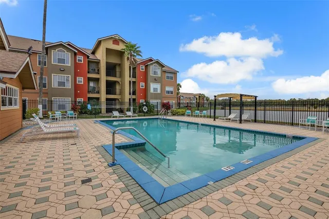 a view of a swimming pool with a table and chairs under an umbrella