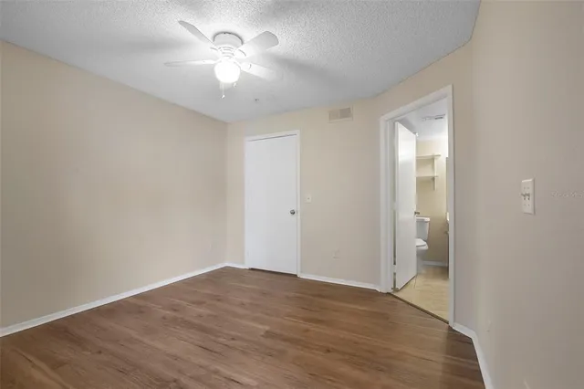 a view of a room with wooden floor and a ceiling fan