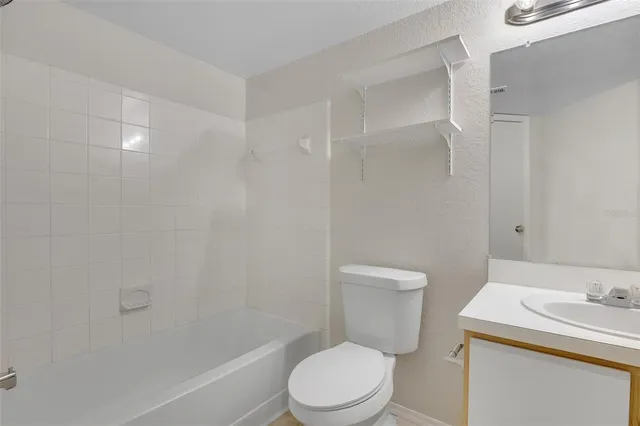 a white toilet sitting next to a bath tub