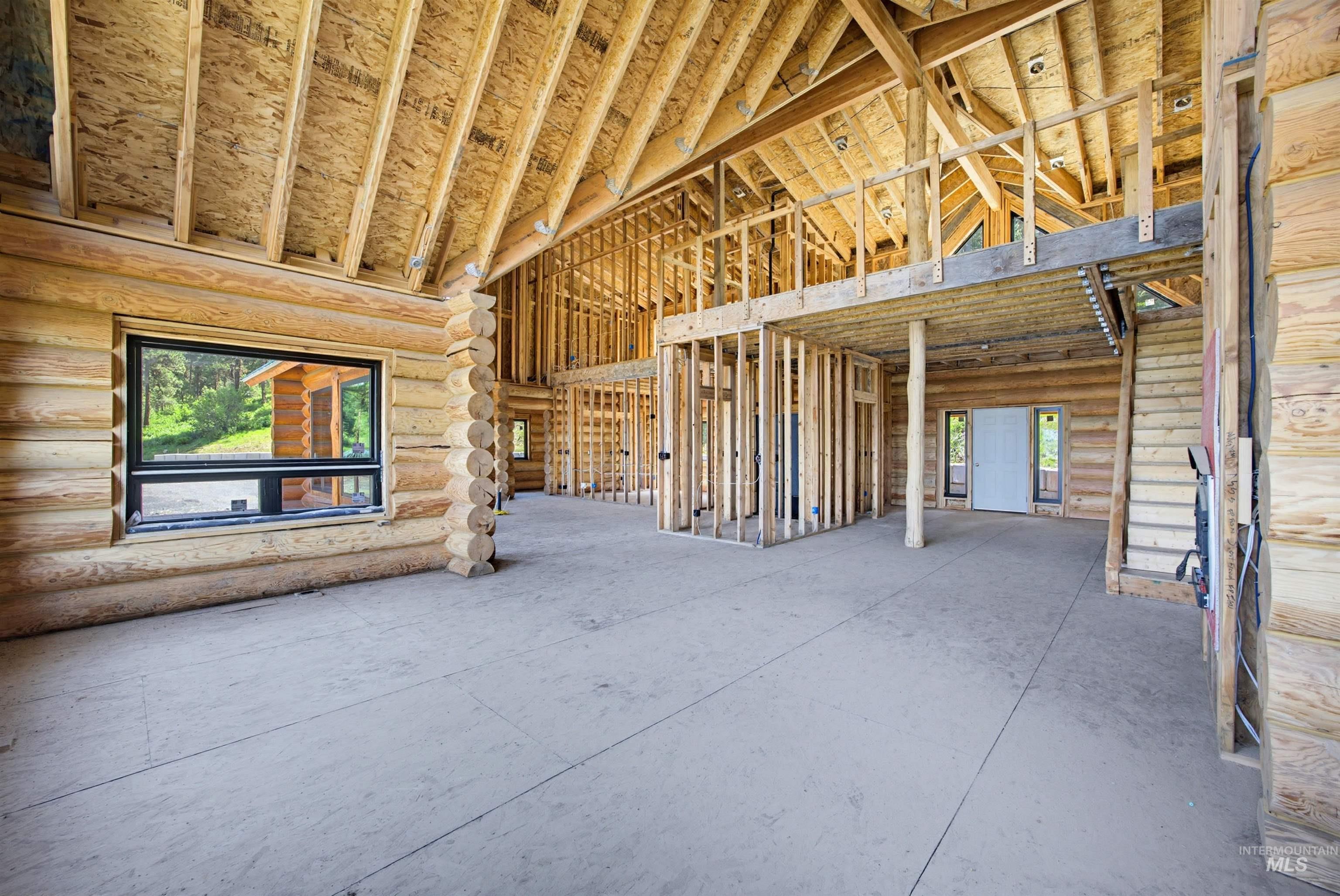 3322 Big Creek Road New Meadows, ID 83654 - Photo 46 of 50 Expansive interior featuring exposed log walls, vaulted ceilings with exposed wood beams, and a concrete slab foundation