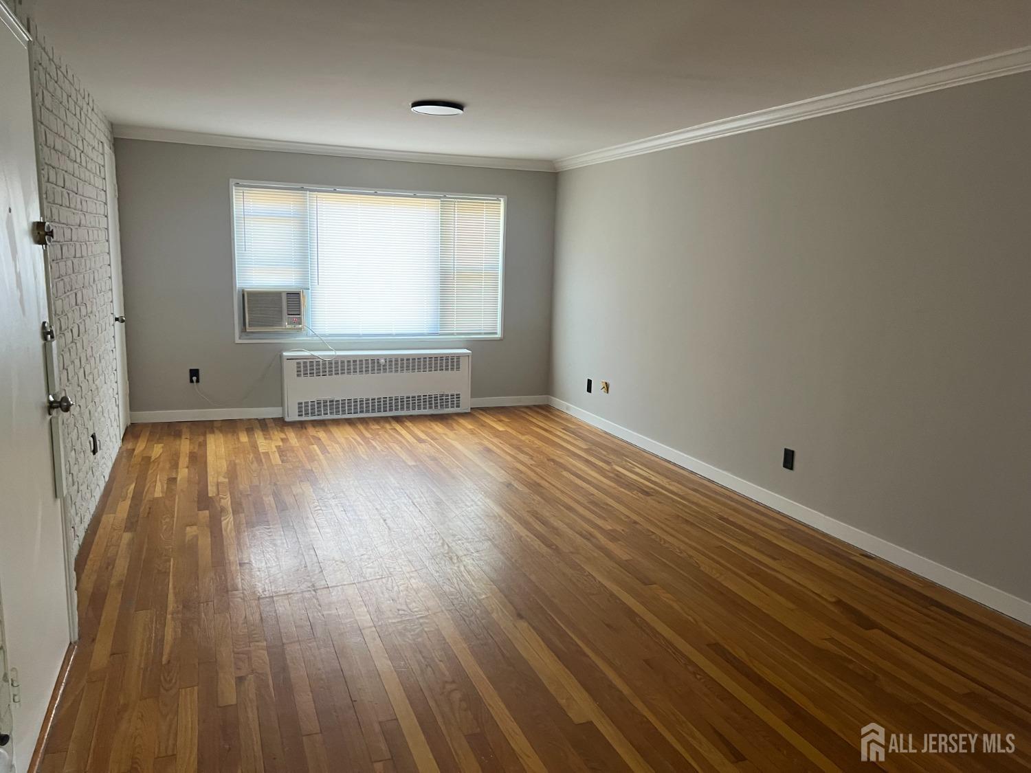 49 B Garfield Park, Unit 4902 Edison, NJ 08837 - Photo 2 of 10 wooden floor in an empty room with a window
