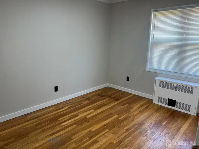a view of a room with wooden floor and a window