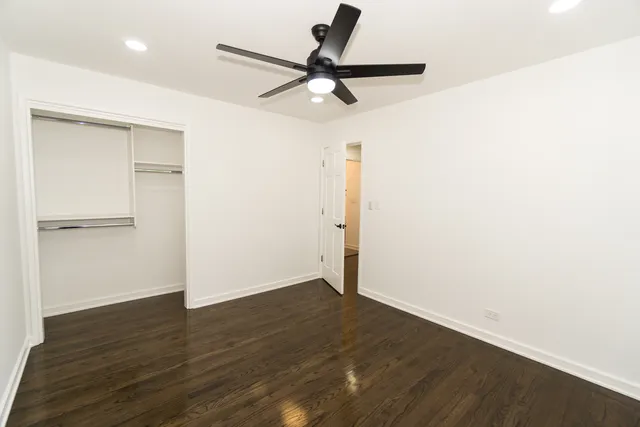 a view of a room with wooden floor and a ceiling fan