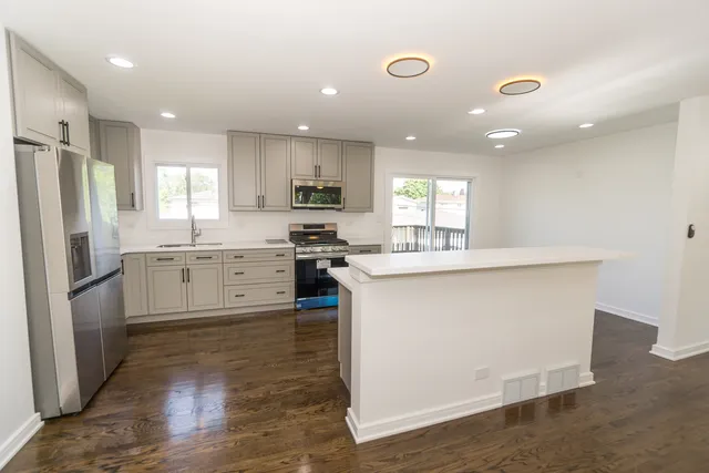 a kitchen with a refrigerator a sink and cabinets
