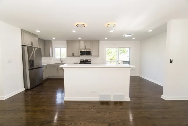 a kitchen with refrigerator cabinets and wooden floor