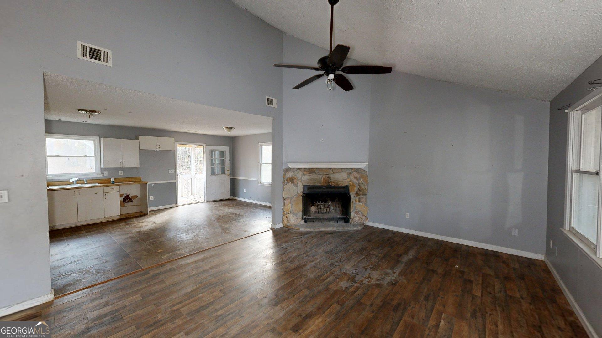 1225 Coppermine Road Buchanan, GA 30113 - Photo 6 of 29 a view of an empty room with a fireplace and a window