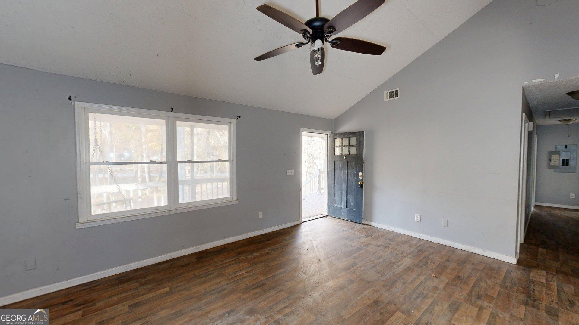 1225 Coppermine Road Buchanan, GA 30113 - Photo 7 of 29 a view of an empty room with wooden floor and a window