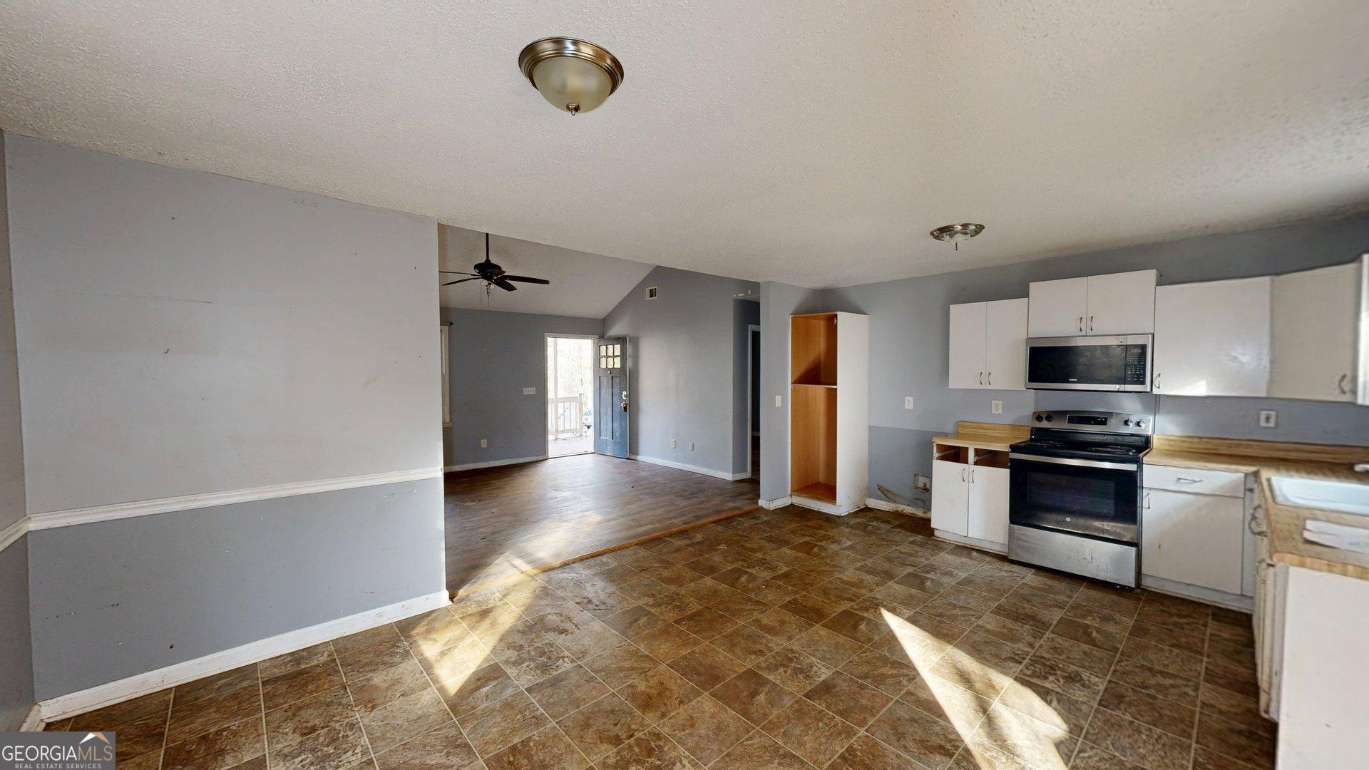 1225 Coppermine Road Buchanan, GA 30113 - Photo 9 of 29 a view of a kitchen with a stove cabinets and a wooden floor