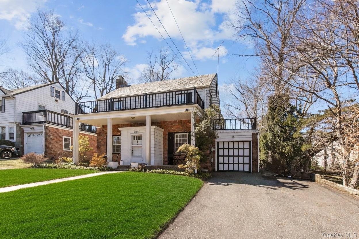 a front view of a house with a garden and trees