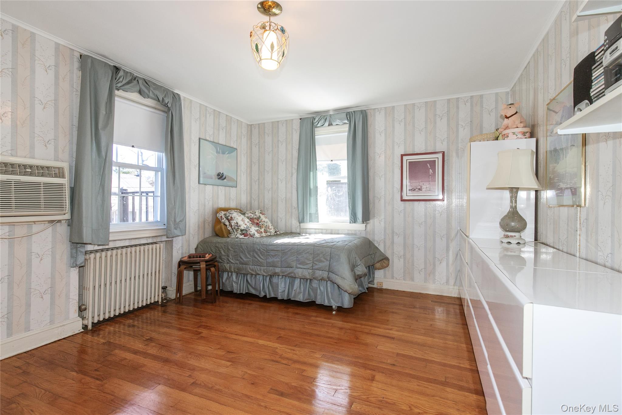 8 Plymouth Road Great Neck, NY 11023 - Photo 16 of 25 a spacious bedroom with a bed and a large window